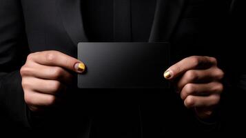 A man is holding a black card with a gold nail polish design on it. The card is blank, but the design on the nails suggests that it could be a blank card for writing a message or drawing a picture photo