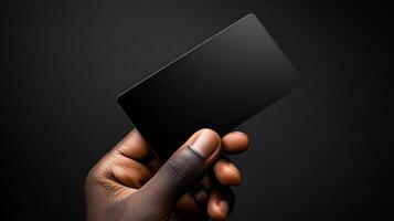 A hand holding a black card. The card is black and has no writing on it. The hand is holding the card in a way that it is almost as if it is being presented to someone photo