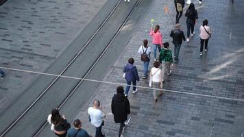 Istanbul, Turkiye - November 2, 2024, Tourist group is walking in Istiklal Street at Istanbul from high angle view, a tourist guide is carrying a flag video