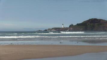 Ocean Waves With Sand Beach In Foreground And Lighthouse Blue Sky In Background Newport Oregon video