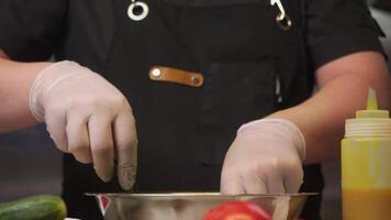 Chef in restaurant's kitchen prepares salad with fresh herbs and honey mustard dressing. chef mixes grass with his hands, making sure that salad is well seasoned with sauce video
