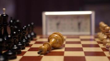 Chess pieces on a chess board with a clock in the background video