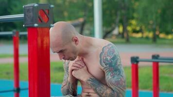 A man with tattoos sitting on a bench video