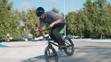 A man on a bike doing tricks in a skate park video