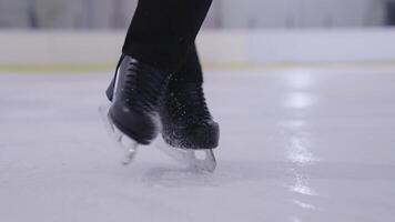 A person wearing black ice skates on a rink video