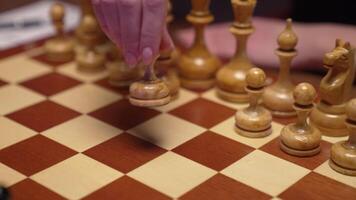 A person is playing chess on a wooden board video