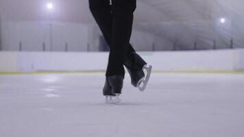 A person in black boots skating on an ice rink video