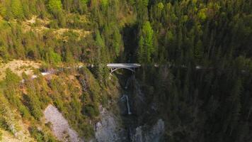 Luftaufnahme Schurpfen Wasserfall. Aerial view of crooked waterfall Schurpfen and bridge in gorge with forested mountain and canyon near Sylvensteinspeicher in Lenggries. Drone view falls and bridge. video