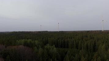 Aerial view of wind farm turbines set up in countryside with forest. Producing power using energy of nature. Incorporating technology into environment of nature. Cloudy sky. Electricity production. video
