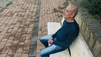 Elderly Man Sitting on the Bench Resting with His Eyes Closed in Calabria Square video