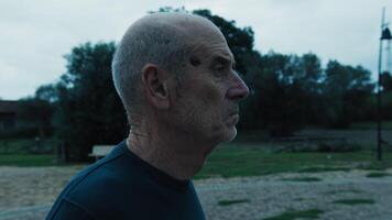 Elderly Man Afraid And Looking Suspicious While Walking In The Park In Evening video