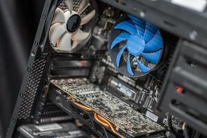 Inside a computer case showcasing components like a graphics card, cooling fan, and intricate circuitry during home assembly photo