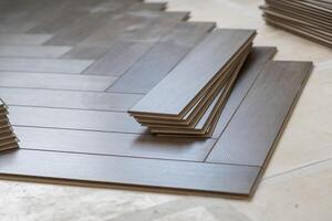 Worker installing laminate flooring in a residential apartment. Tools, planks photo