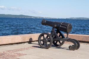 The cannon stands prominently on the shores of Lake Onega, overlooking the water and highlighting local historical significance photo