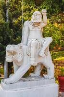 white Buddhist statue of Buddha sitting on a lion in park at the Linh Ung Pagoda in Da Nang in Vietnam in summer in Asia photo