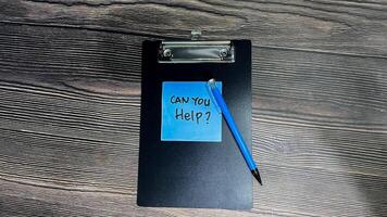 Concept of Can You Help write on sticky notes isolated on Wooden Table. photo