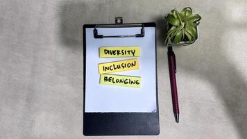 Concept of Diversity, Inclusion, Belonging write on sticky notes isolated on Wooden Table. photo