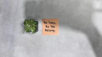 Concept of Be Here, Be You, Belong write on sticky notes isolated on Wooden Table. photo