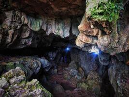 Mysterious Cave Interior with Narrow Passage and Stalactite Formations photo
