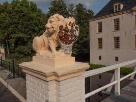 A lion statue on a bridge in front of a building photo