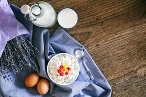 Dairy products on dark wooden table. Sour cream, milk, cheese, egg. Top view with copy space photo