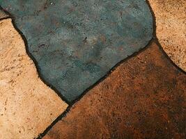 Abstract texture of stone pavement with earthy tones and dark outlines. The image showcases the natural patterns and colors, highlighting the artistic design of the surface. photo