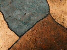 Abstract texture of stone pavement with earthy tones and dark outlines. photo