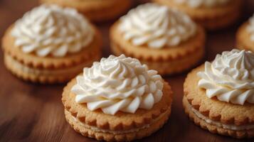 Delicious cookies topped with swirls of white cream cheese frosting resting on dark surface photo