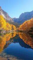 Maroon bells reflecting in crystal clear lake during peak fall foliage in aspen, colorado photo