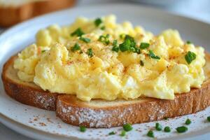 Scrambled eggs with chives and paprika resting on toasted bread for a healthy breakfast photo