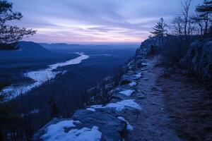 Sunrise illuminating snowy mountain path and frozen river photo