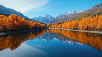 Autumn foliage reflecting in mountain lake with snow capped peaks photo