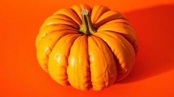 Close-up of a Single Orange Pumpkin on a Red Background photo