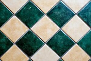 Classic ceramic tile background featuring dark green and taupe matte tiles with textured surfaces and subtle wear photo