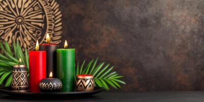 Kinara with red, green, and black candles on a dark table surrounded by decorative African patterns and holiday symbols photo