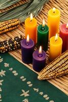 Kwanzaa celebration symbols featuring colorful candles and unity cup on a woven mat with African patterns photo