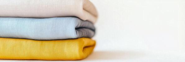 Softly folded light blue-gray fabrics stacked for an organized textile display in a serene setting photo