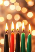 Kwanzaa candles burning in red, black, and green with festive lights in the background creating a cozy atmosphere photo
