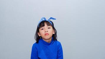 Beautiful kid girl standing over isolated grey background looking sleepy and tired, exhausted for fatigue and hangover, lazy eyes and boredom photo