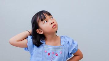 Young Asian girl confuse and wonder about question. uncertain with doubt, thinking with hand on head. little girl pensive concept. photo
