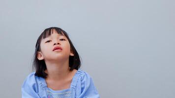 Beautiful kid girl standing over isolated grey background looking sleepy and tired, exhausted for fatigue and hangover, lazy eyes in the morning. photo