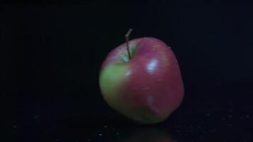 Rotating apple in slow motion on a black background video