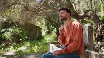 Philosopher Boy Thinks Seated Under The Olive Tree With Pencil And Notebook video