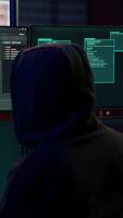 vertical com experiência hacker escrevendo linhas do código em computador a partir de subterrâneo bunker, amarrar para pegue passado segurança sistemas. Vampiro programador construção scripts este pode hackear dispositivos, Câmera uma video