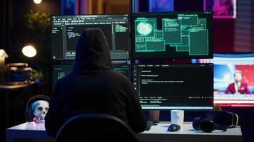 Malicious man hacking, stealing credit card numbers and manipulating banking systems for own personal gain. Evil hacker running code in apartment on computer monitor, camera A video