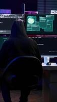 Vertical Malicious man hacking, stealing credit card numbers and manipulating banking systems for own personal gain. Evil hacker running code in apartment on computer monitor, camera B video
