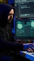 Vertical Hacker stealing credit card numbers while listening music through headphones. Evil developer programming in apartment, infiltrating banking systems, hearing songs, camera A video