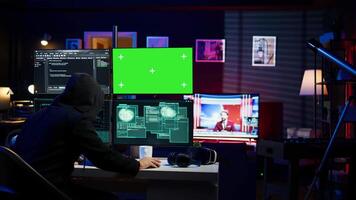 Rogue programmer using green screen PC to hack firewalls, getting attacks rejected by cybersecurity. Scammer using mockup monitor seeing access denied error message while committing fraud, camera B video