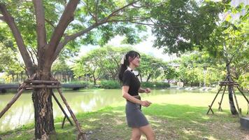 Asian girl dancing and cheering, moving her arms Inside the park during the day video