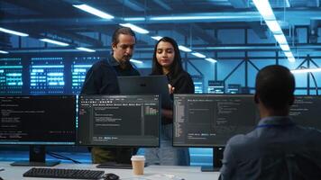 Multiethnic team of admins working in high tech server room capable of storing vast amounts of data. Diverse colleagues doing brainstorming, discussing ways to fix servers video